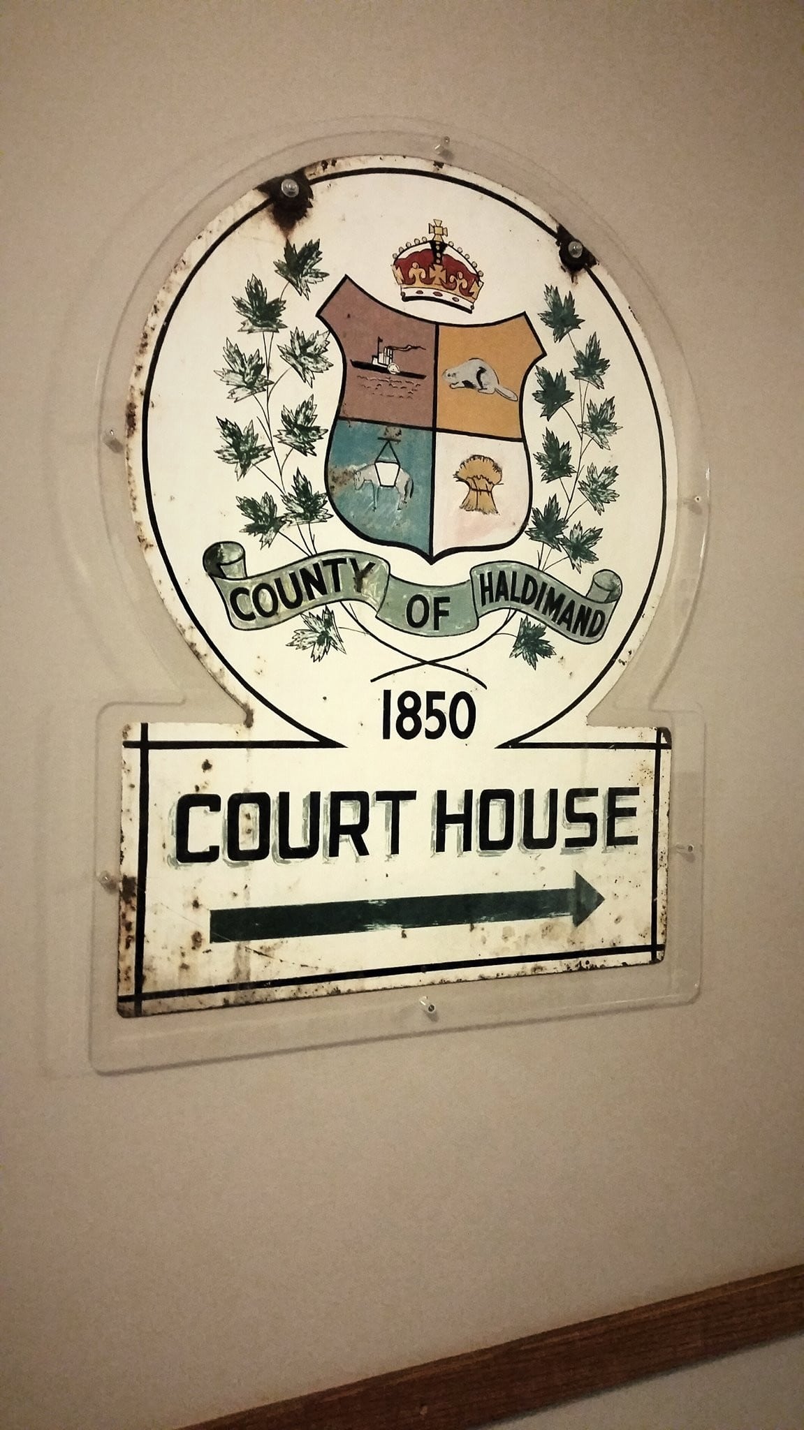 Historic County of Haldimand Court House sign dating to 1850, featuring the Haldimand County coat of arms, displayed at the Cayuga Courthouse in Ontario